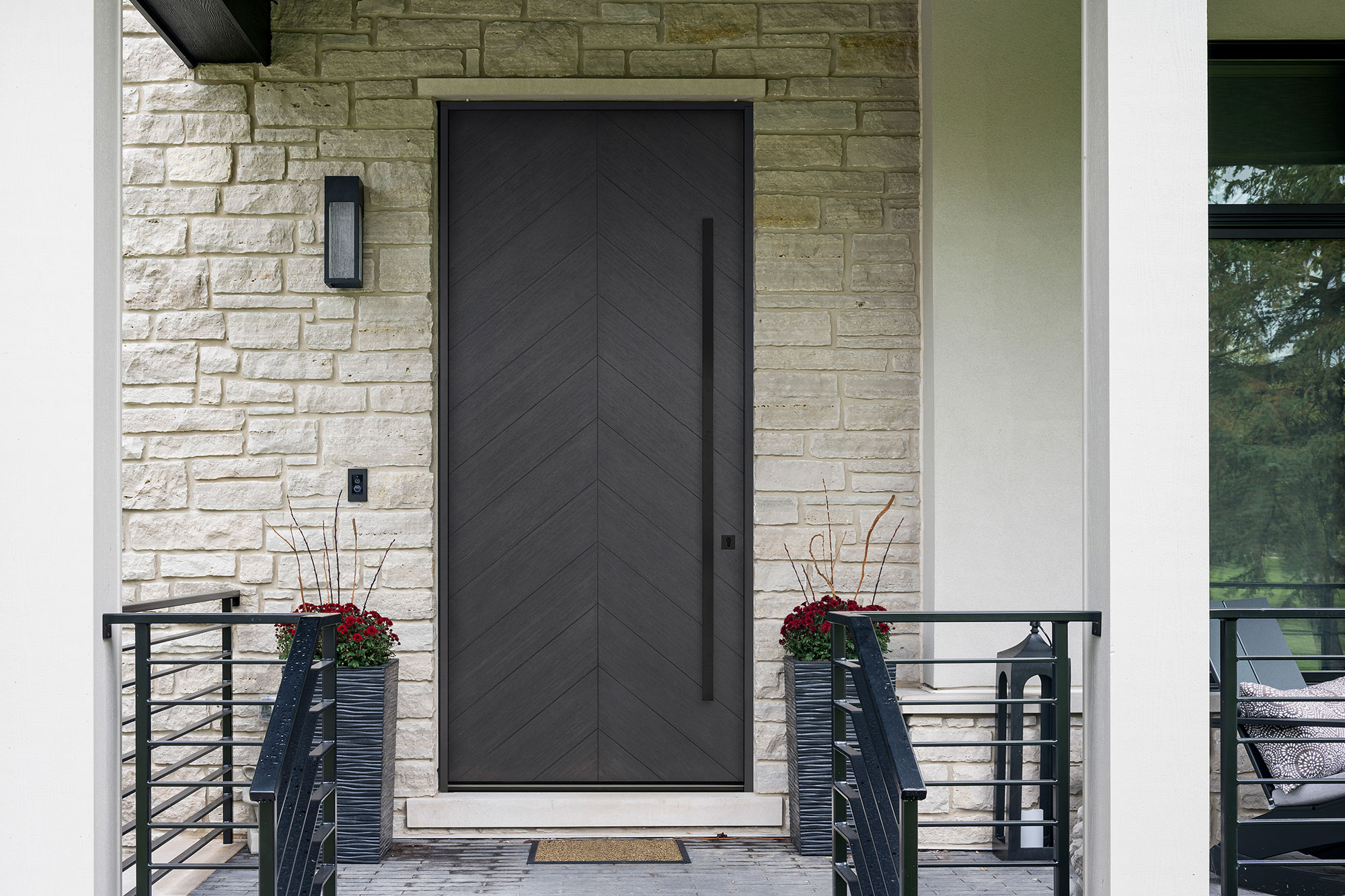 Elegant white exterior door framed by sidelights and transom window in a colonial-style house.